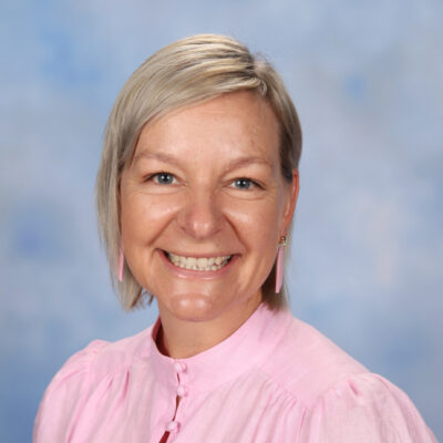 portrait of a professional woman in light pink shirt with blonde hair, smiling